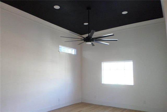 spare room with light wood-type flooring, ceiling fan, and baseboards