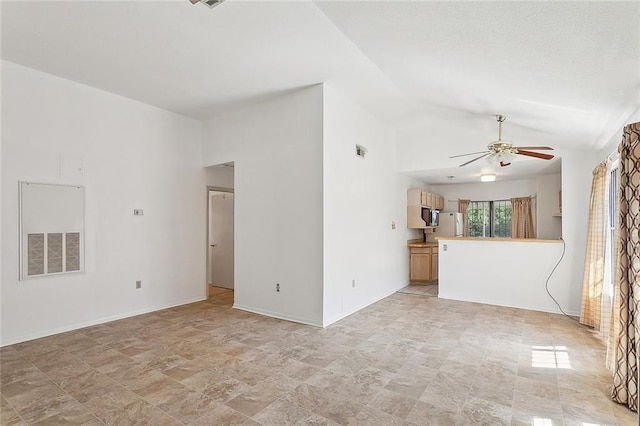 unfurnished living room with lofted ceiling, baseboards, visible vents, and a ceiling fan