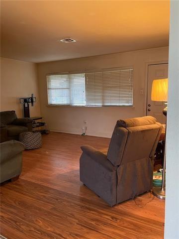 living area featuring wood finished floors and visible vents