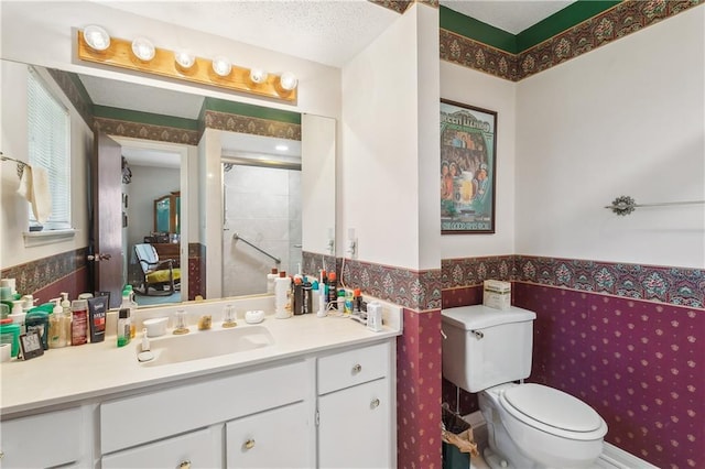 108 Bertel Dr, Covington, LA 70433 - full bathroom featuring vanity, toilet, a textured ceiling, a shower stall, and a wainscoted wall
