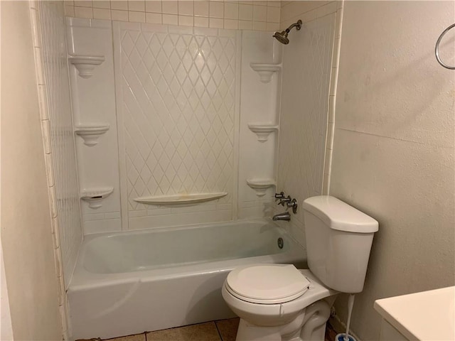 bathroom featuring a textured wall, toilet, vanity, tile patterned floors, and washtub / shower combination