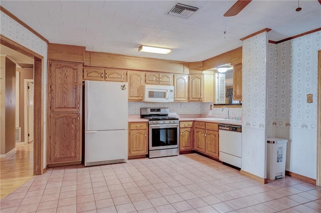 kitchen with light countertops, white appliances, visible vents, and wallpapered walls