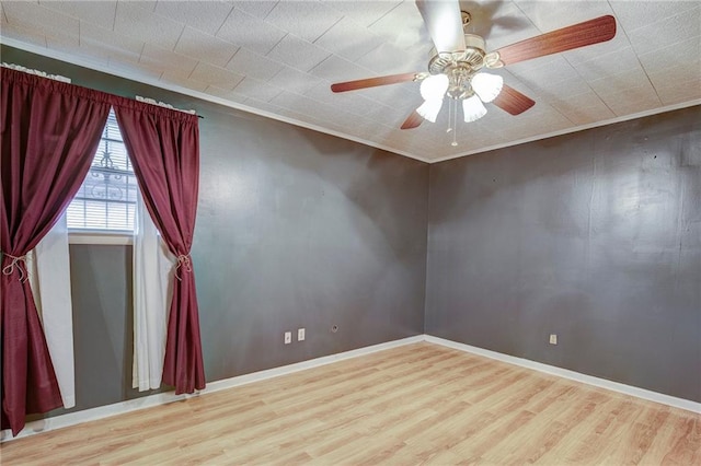 empty room with ceiling fan, baseboards, and wood finished floors