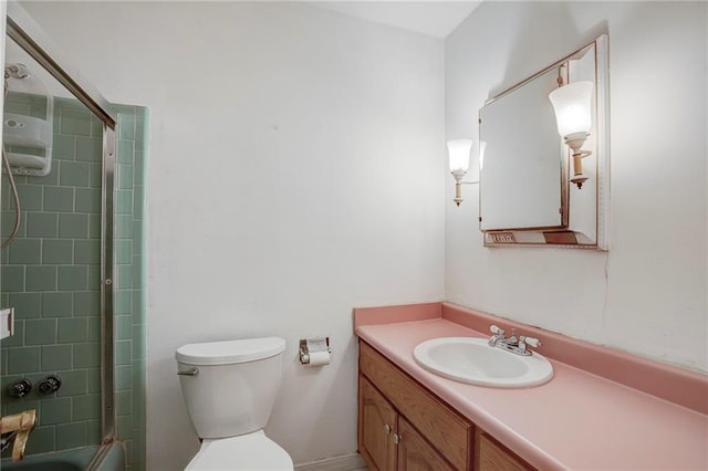 full bathroom featuring toilet, enclosed tub / shower combo, and vanity