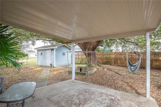 view of patio with an outbuilding, a fenced backyard, and a storage unit