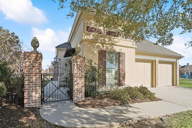 view of front facade with a garage, a shingled roof, a gate, fence, and stucco siding