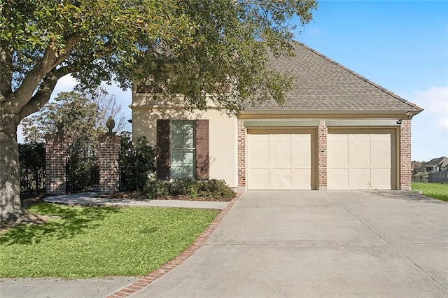 view of front of house featuring a garage, a shingled roof, concrete driveway, a front yard, and brick siding