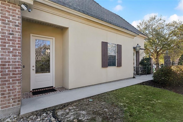 exterior space with a shingled roof and brick siding