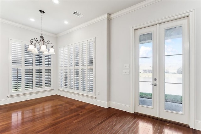 unfurnished dining area with wood-type flooring, visible vents, ornamental molding, and french doors