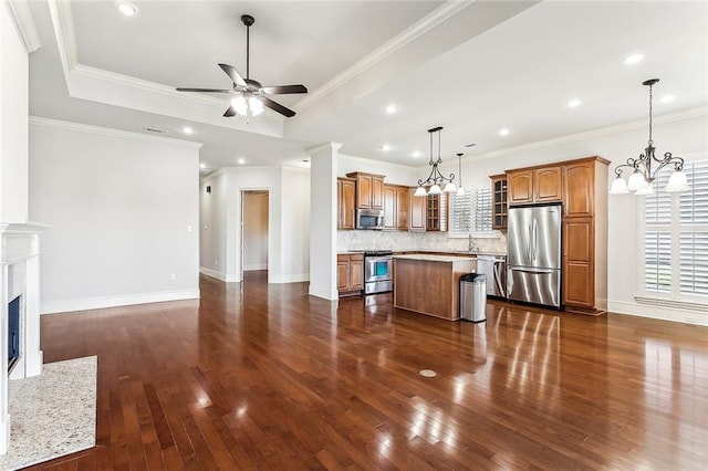 unfurnished living room featuring baseboards, a raised ceiling, dark wood-style flooring, a fireplace, and ceiling fan with notable chandelier