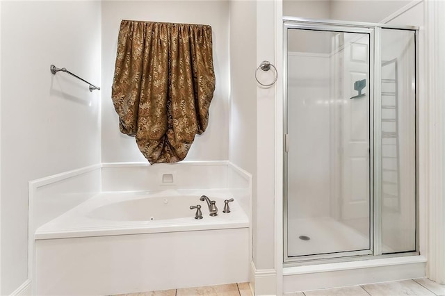 bathroom with tile patterned flooring, a shower stall, and a bath