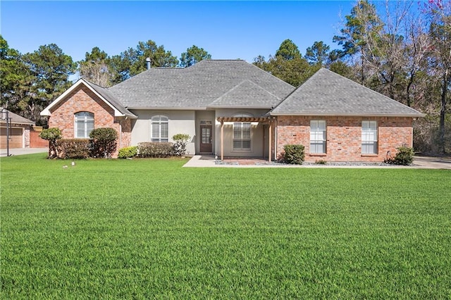 ranch-style house with a shingled roof, brick siding, a front lawn, and stucco siding