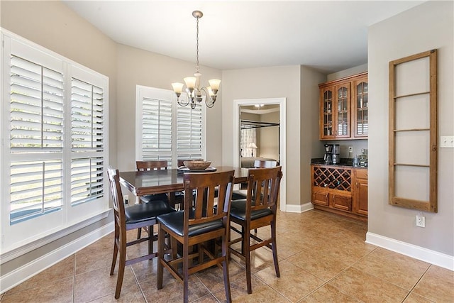 dining room with light tile patterned floors, a notable chandelier, and baseboards