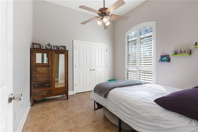 bedroom featuring light tile patterned floors, multiple windows, a closet, and baseboards