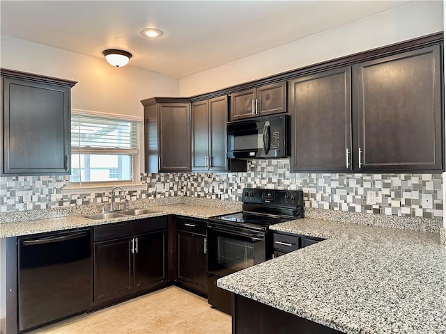 kitchen featuring dark brown cabinetry, a sink, backsplash, and black appliances