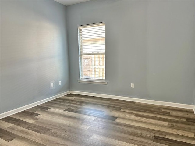 unfurnished room with wood finished floors and baseboards