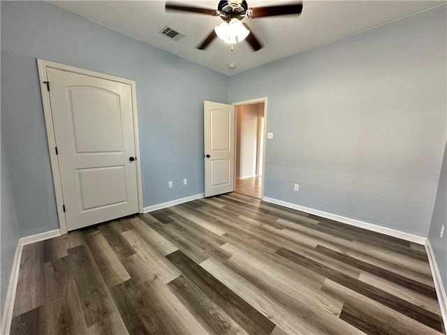 unfurnished bedroom with a ceiling fan, baseboards, visible vents, and wood finished floors