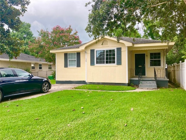 view of front of property featuring fence and a front lawn