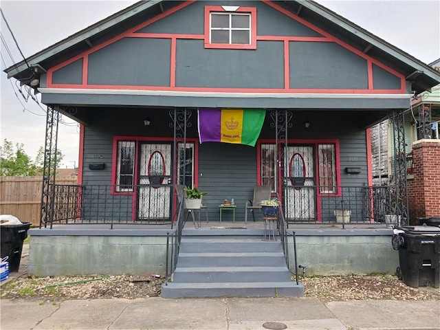 view of front of property with covered porch and fence