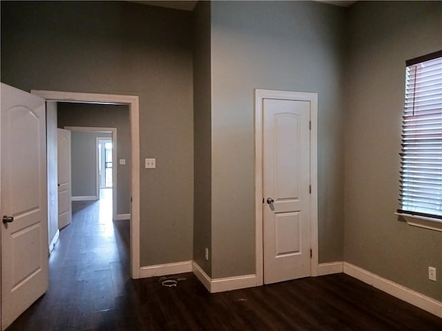 hall featuring baseboards and dark wood-style flooring