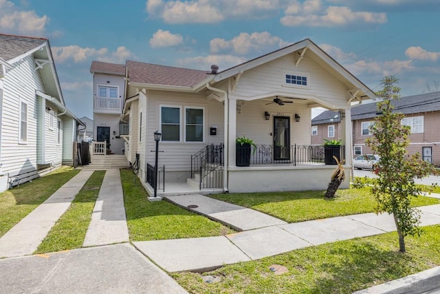 view of front of property with covered porch, a front lawn, and a ceiling fan