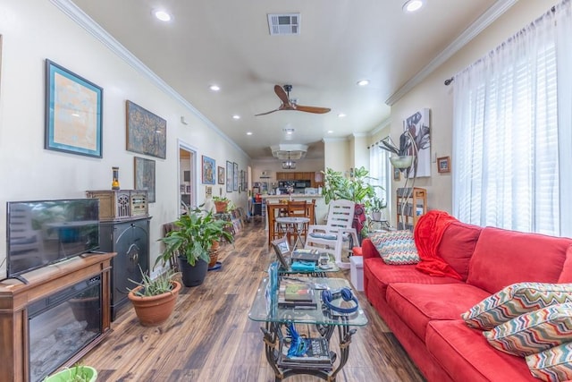 living room featuring recessed lighting, visible vents, wood finished floors, and ornamental molding