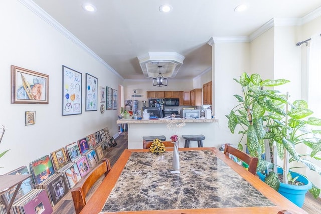 dining area with ornamental molding, recessed lighting, and light wood-style floors