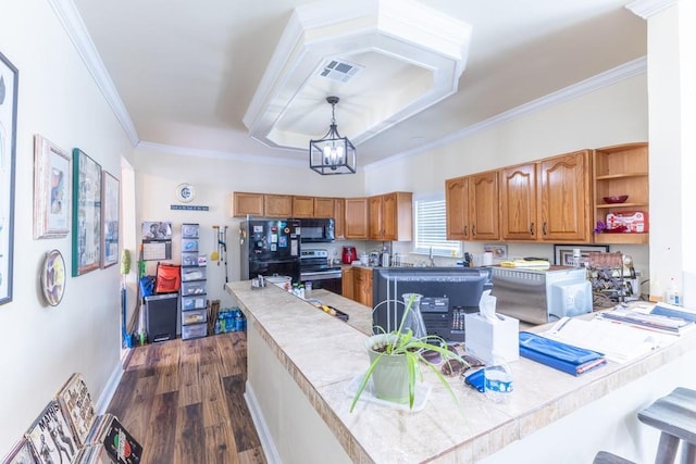 kitchen featuring visible vents, ornamental molding, dark wood-style flooring, a peninsula, and black appliances