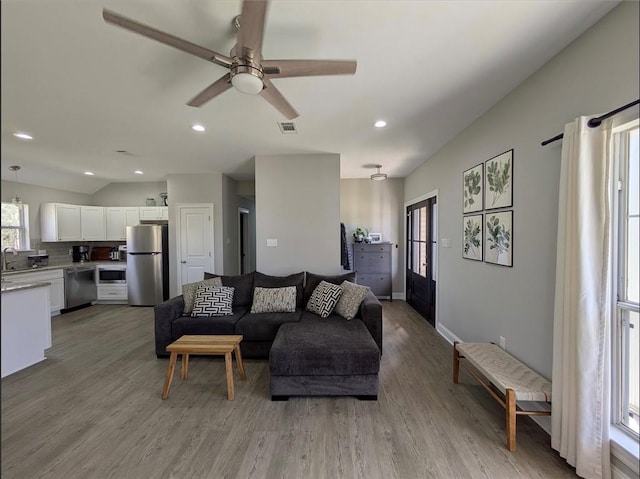 living area with baseboards, visible vents, ceiling fan, light wood-type flooring, and recessed lighting