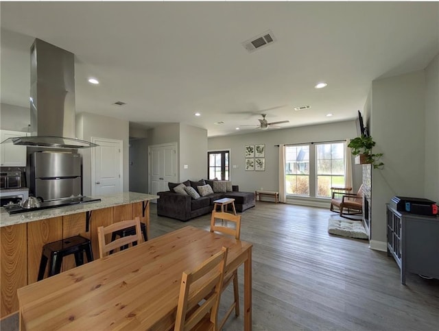 dining space with wood finished floors, visible vents, and recessed lighting