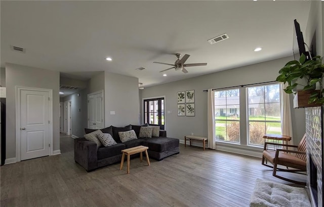 living area featuring baseboards, visible vents, wood finished floors, and recessed lighting