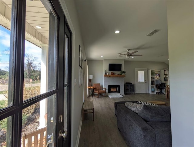 living room featuring visible vents, a ceiling fan, wood finished floors, a brick fireplace, and recessed lighting