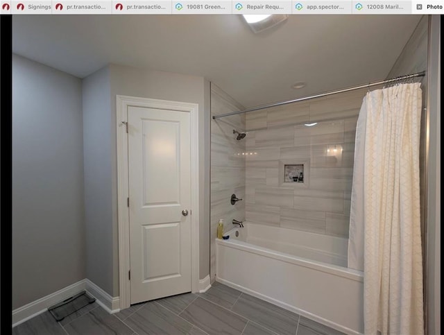 bathroom featuring baseboards and shower / tub combo with curtain