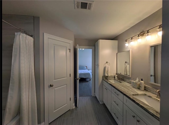 bathroom with double vanity, visible vents, wood tiled floor, a sink, and a shower with curtain