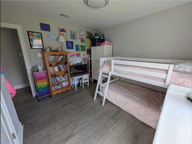 bedroom featuring visible vents, baseboards, and wood finished floors