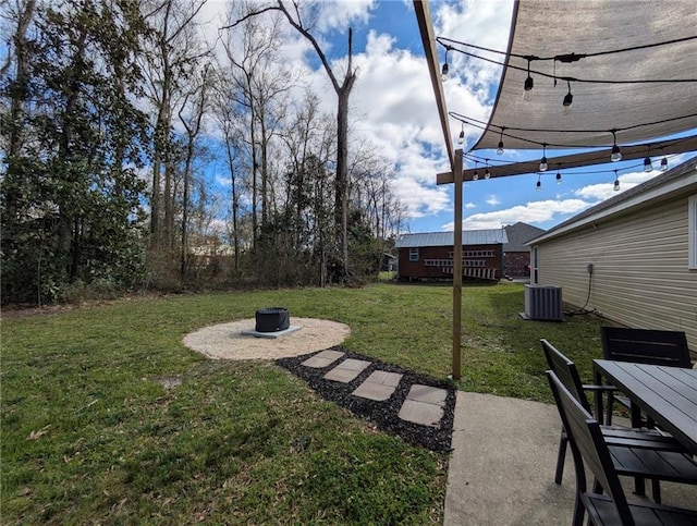 view of yard featuring a fire pit and central AC unit