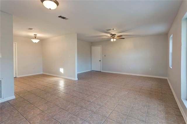 unfurnished room featuring visible vents, ceiling fan, and baseboards