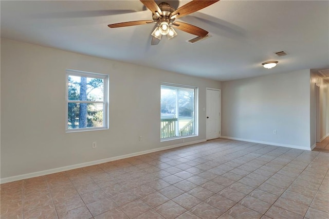 spare room featuring plenty of natural light, visible vents, and baseboards