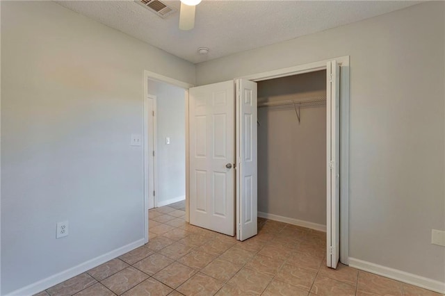 unfurnished bedroom with a closet, visible vents, a textured ceiling, and baseboards