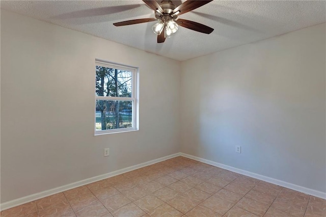 spare room with a ceiling fan, a textured ceiling, and baseboards