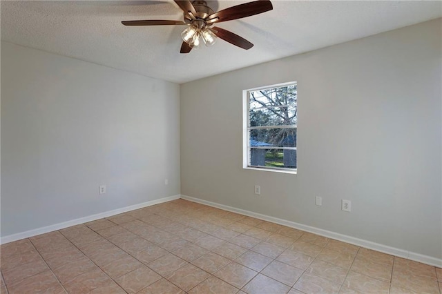 spare room featuring a ceiling fan, a textured ceiling, and baseboards