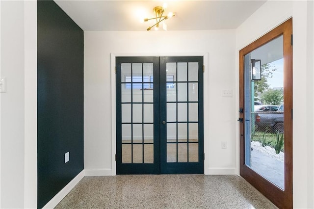 doorway to outside with french doors, baseboards, an inviting chandelier, and speckled floor