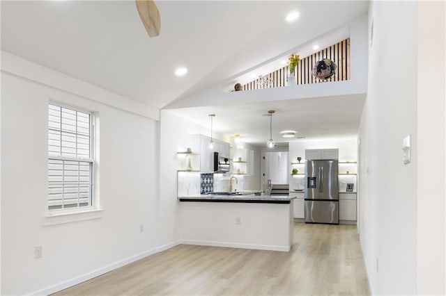 kitchen featuring open shelves, light wood-style floors, appliances with stainless steel finishes, a peninsula, and hanging light fixtures