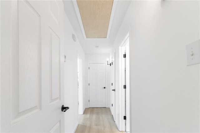 hallway with attic access and light wood finished floors