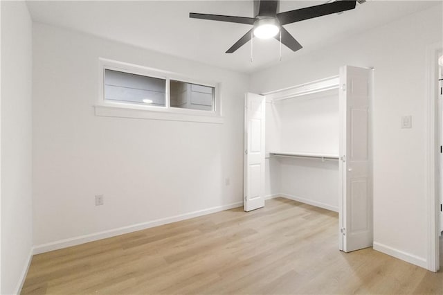 unfurnished bedroom with a closet, baseboards, wood finished floors, and a ceiling fan