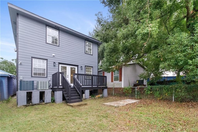 rear view of house featuring fence, a yard, cooling unit, french doors, and a wooden deck