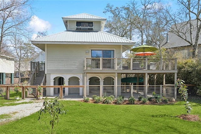 back of house featuring metal roof and a yard