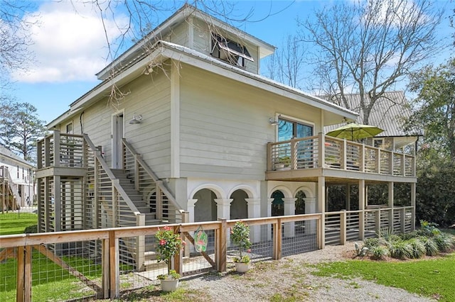 view of property exterior featuring fence and stairs