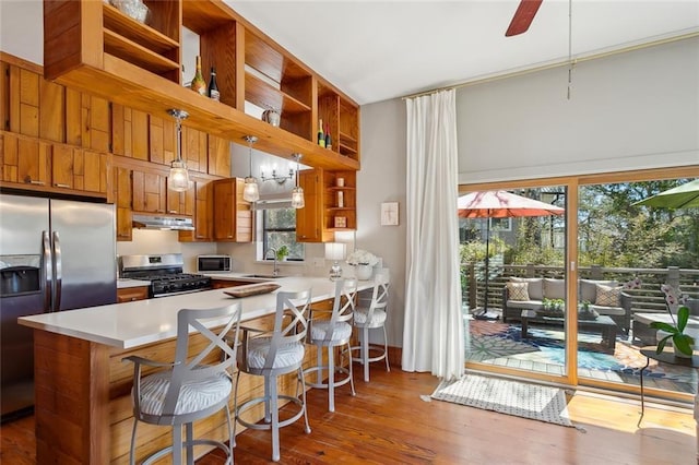 kitchen featuring stainless steel appliances, light countertops, under cabinet range hood, open shelves, and a sink