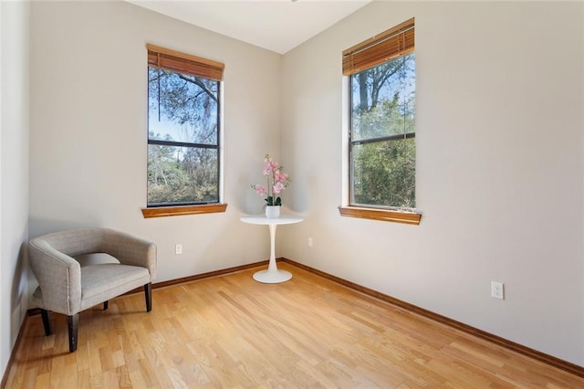 living area with light wood-style flooring and baseboards